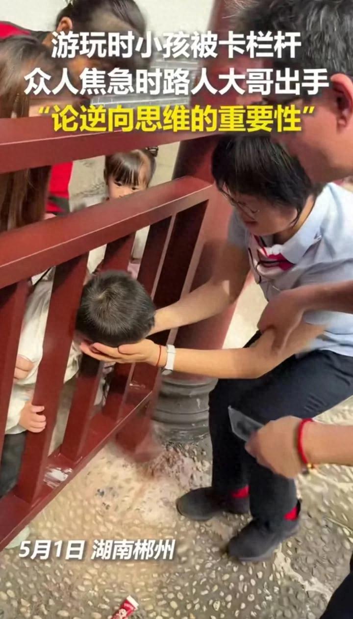 五放假玩小孩头 被卡拦杆关键时刻，路人大哥出手逆向思维成功救出